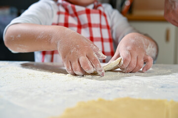 Child hands kneading dough