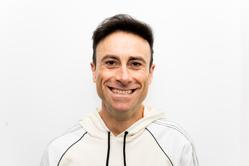 Portrait photograph of a Caucasian adult man between 40 and 50 years old is looking happily at the camera. Concept of positive, joyful looks at success, motivation and self-improvement in sport.