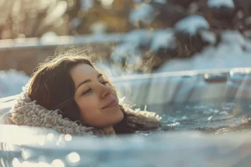 Papier Peint photo Spa A woman relaxing in a hot tub surrounded by snow. Perfect for winter spa concepts