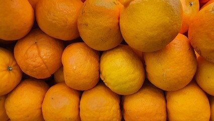 Close up pile of tasty fresh oranges sold at the market as a background.