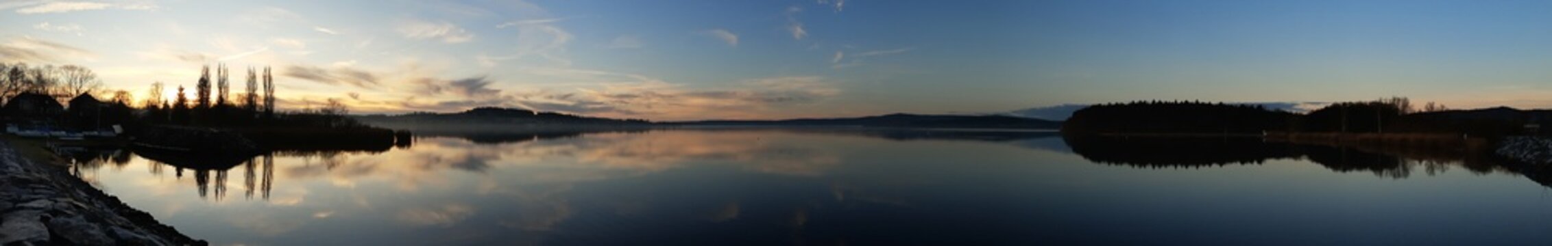 panorama picture of the sunrise over the lake with the reflection in the lake