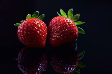 two strawberry peaces isolated on black background