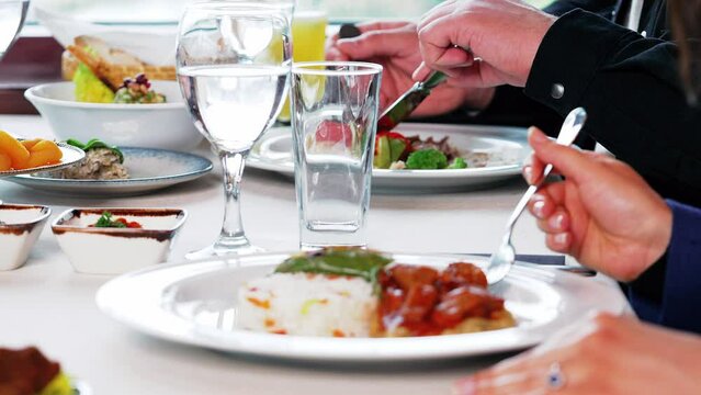 The woman is eating Hunkar liked it and the waiter is serving lemonade.