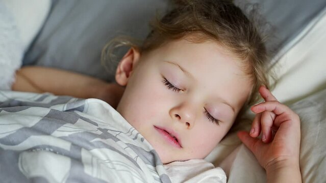 Cute little girl sleeping and grinding teeth in dreams, clenched teeth with tiredness and stress 