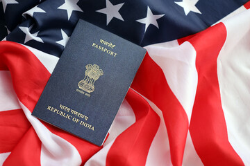 Fototapeta premium Blue Indian passport on United States national flag background close up. Tourism and diplomacy concept