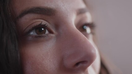 Close up on beautiful women's face opening her eyes and watching a screen