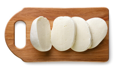 Mozzarella ball cut into pieces on a kitchen board on a white background. Top view