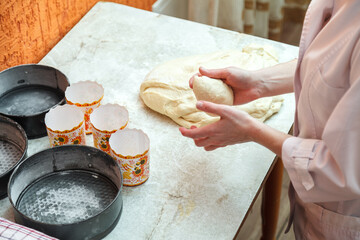 The confectioner girl prepares the dough for baking Easter cakes and stacked them into special forms