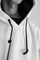 A man wearing a white hoodie with a black hood. Suitable for fashion or urban lifestyle concepts