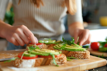 Obraz na płótnie Canvas close-up, girl preparing sandwiches with avocado, slices of vegetables on bread, vegetarian breakfast