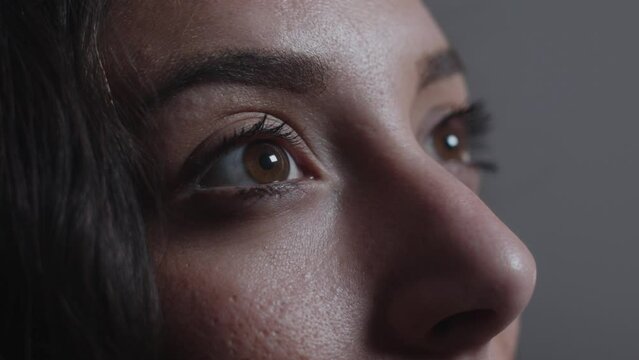 Young European female reacts to a screen close up on eyes