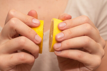 Hands Showcasing Half a Lemons. A person's fingers displaying a bright lemon half.