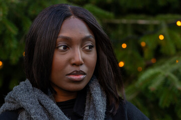 Captured against a backdrop of a fir tree adorned with twinkling lights, this image features a...