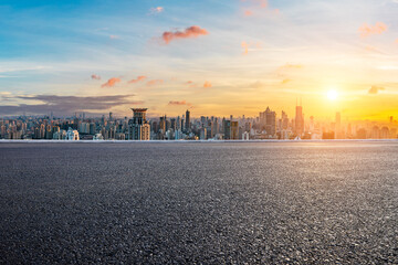 Asphalt road and city skyline with modern buildings at sunset in Shanghai