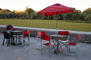 Empty Tables and Red Chairs along the Beautiful Buenos Aires Ecological Reserve Lagoon