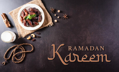 Ramadan Kareem background concept, Rosary bead with dates fruit, milk and the text on dark stone background.