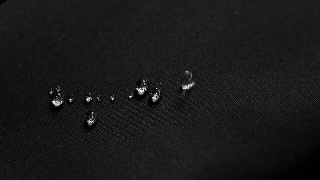 Water drops on waterproof black fabric.