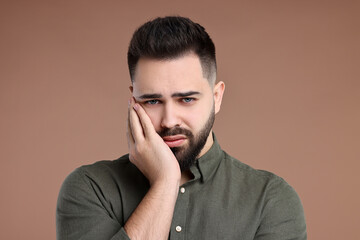 Portrait of sad man on brown background