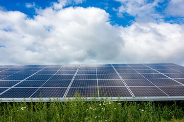 Photovoltaikanlage zur Stromerzeugung auf einem Acker vor wolkigem Himmel - 761557368