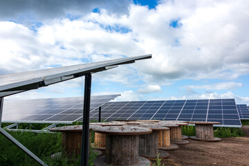 Photovoltaikanlage zur Stromerzeugung auf einem Acker vor wolkigem Himmel - 761557386