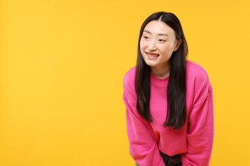 Fototapeta premium Portrait of smiling woman on orange background. Space for text