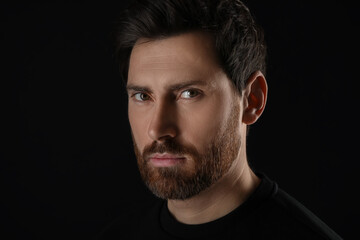 Fototapeta premium Evil eye. Man with scary eyes on black background, closeup