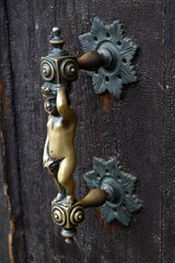 Vieille poignée de porte avec une statuette en bronze d'une porte de maison vénitienne en gros plan