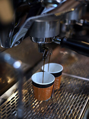 cafetera industrial llenando vasos con café expreso