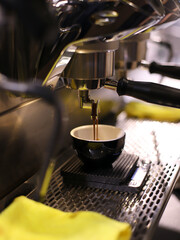 industrial coffee maker filling a cup of coffee