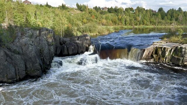 Voytsky padun waterfall in autumn. The famous powerful and wide Karelian waterfall Voytsky Padun is surrounded by rocks and greenery. Cascading waterfall on the river. Karelia, Russia 4K
