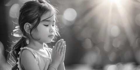 Happy Little girl praying in the morning.Little asian girl hand praying,Hands folded in prayer concept for faith, worship, spirituality and religion.black and white tone.