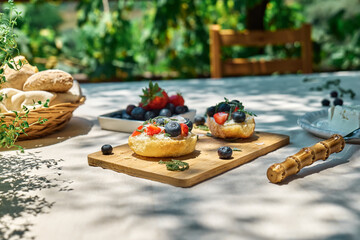Toast with cream cheese, blueberry, strawberry, coconut flakes and herbs for summer picnic or...