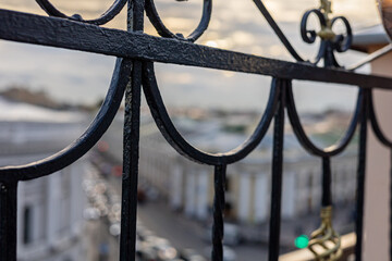 Metal balustrade close up and the blurred Bird's-eye view of the historical center of Saint Petersburg through the balustrade