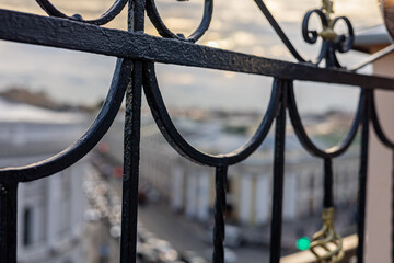 Metal balustrade close up and the blurred Bird's-eye view of the historical center of Saint...