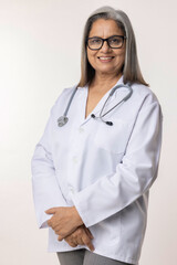 Portrait of smiling confident senior female doctor wearing lab coat standing against white background