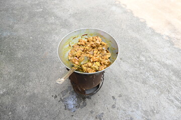 Cooking Goat meat in a Frying Pan on coal Stove at Home Kitchen. Sizzling chunks of juicy Goat meat fillet, with onions. Home delicious food. Make indian Goat meat curry in traditional style.
