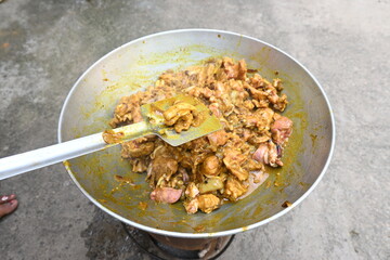 Cooking Goat meat in a Frying Pan on coal Stove at Home Kitchen. Sizzling chunks of juicy Goat meat fillet, with onions. Home delicious food. Make indian Goat meat curry in traditional style.