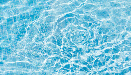 Clear water surface with ripple wave splashes and drops in swimming pool. Abstract turquoise or blue texture water wave and sunlight shadow reflections for background. Banner.