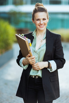 smiling modern business woman near business center