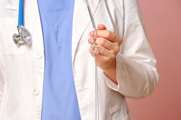 Woman doctor holding Jewish religious symbol, studio pink background. Nurse in uniform with stethoscope on red studio background - obrazy, fototapety, plakaty