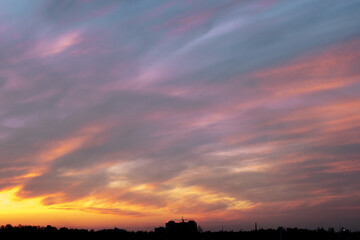 Gray-blue gloomy dull sky at sunset, evening twilight, silhouette of the city on the horizon