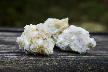 Golden mica raw crystal stones mineral on wooden rustic table.