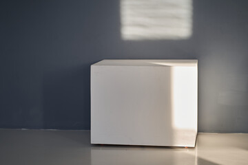 White square podium for placing goods, products, items for advertising on grey wall. Mock up,...