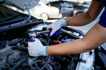 A mechanic is working on a car engine, using a wrench to loosen a bolt. Concept of focus and...