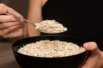Serving Oats with a Spoon. Scooping oats from a bowl with a metal spoon.