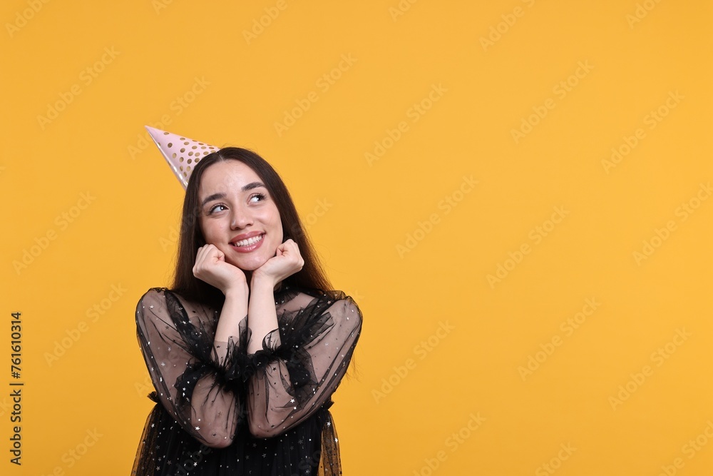 Canvas Prints Happy woman in party hat on orange background, space for text