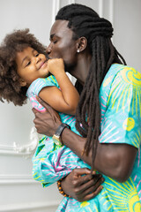 stylish african dad kisses his cute daughter