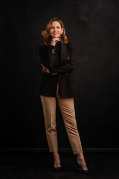 Full length of an attractive mid aged woman wearing business clothes and standing against isolated background