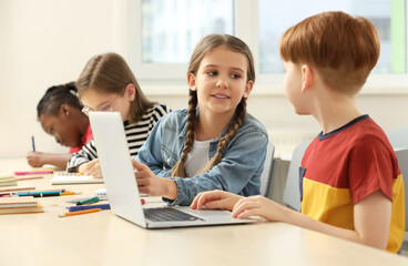 Cute children studying in classroom at school