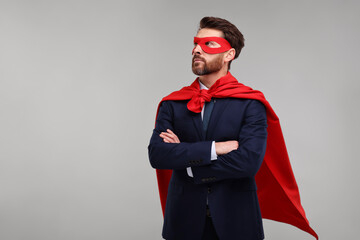 Confident businessman wearing red superhero cape and mask on beige background. Space for text